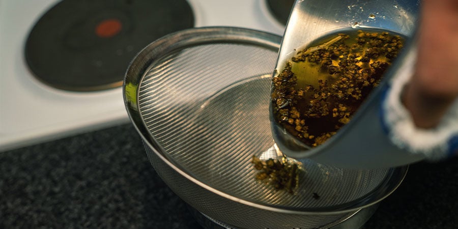 Filtra la mezcla con un colador fino para separar el cannabis del aceite