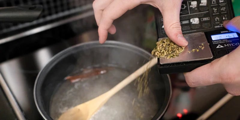 Añade el cannabis descarboxilado al cazo y cocina a fuego lento durante 20 minutos, revolviendo de vez en cuando.