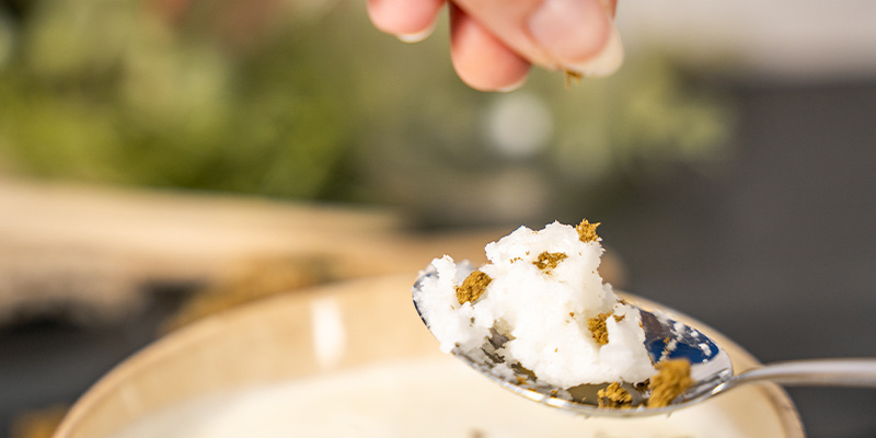 Para empezar, pon un poco de aceite de coco en la cuchara y desmenuza el hachís por encima.